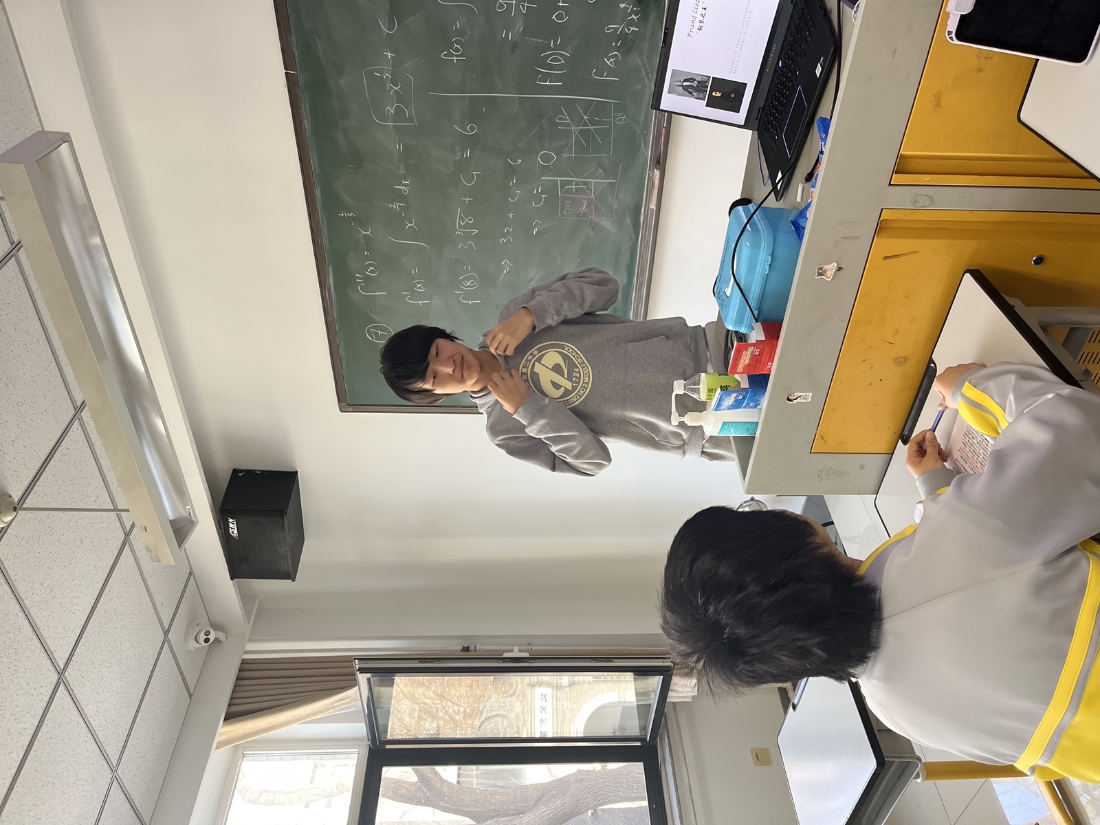 James speaking in front of a blackboard during the classical music club.